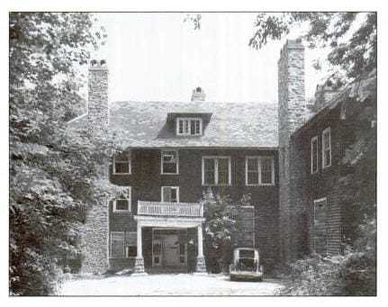 A black and white photograph of the Leiter house showing the driveway surrounded by forestry.